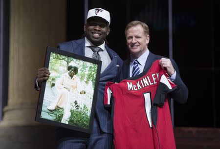 Apr 27, 2017; Philadelphia, PA, USA; Takkarist McKinley (UCLA) poses with NFL commissioner Roger Goodell as he holds a photo of his grandmother as he is selected as the number 26 overall pick to the Atlanta Falcons in the first round the 2017 NFL Draft at the Philadelphia Museum of Art. Bill Streicher-USA TODAY Sports