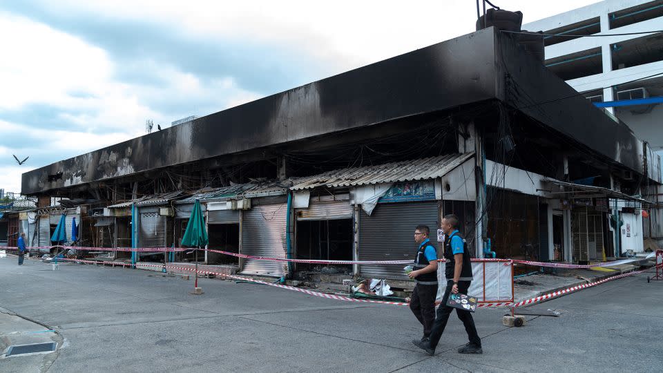 Forensics officers survey the area following the fire. - Chanakarn Laosarakham/AFP/Getty Images