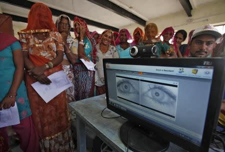 Village women stand in a queue to get themselves enrolled for the Unique Identification (UID) database system at Merta district in the desert Indian state of Rajasthan February 22, 2013. REUTERS/Mansi Thapliyal/File Photo