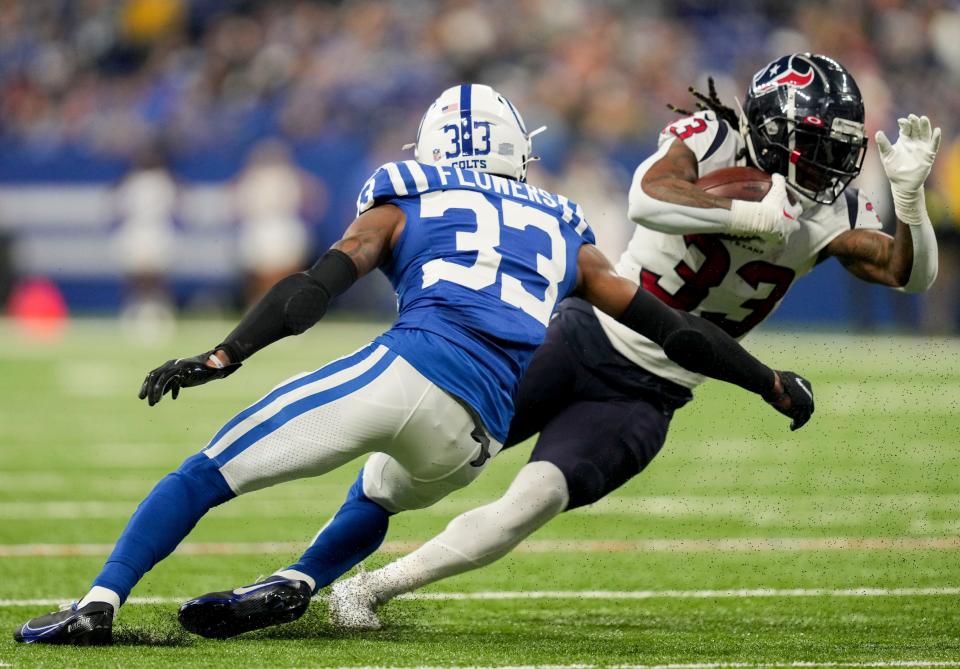 Indianapolis Colts cornerback Dallis Flowers (33) reaches for Houston Texans running back Dare Ogunbowale (33) as he rushes the ball Sunday, Jan. 8, 2023, during a game against the Houston Texans at Lucas Oil Stadium in Indianapolis.