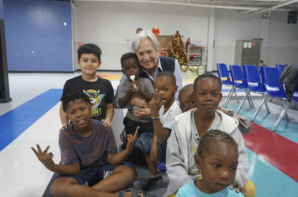 Sister Norma Pimentel, the director of Catholic Charities of the Rio Grande Valley, plays with migrant children on the floor of the Humanitarian Respite Center in McAllen, Texas, on Dec. 15, 2022. The Catholic nun has been ministering to migrants in the area for forty years, and worries that a broken asylum system with often shifting policies creates even more tensions among migrants and makes it impossible to help them all. (AP Photo/Giovanna Dell'Orto)