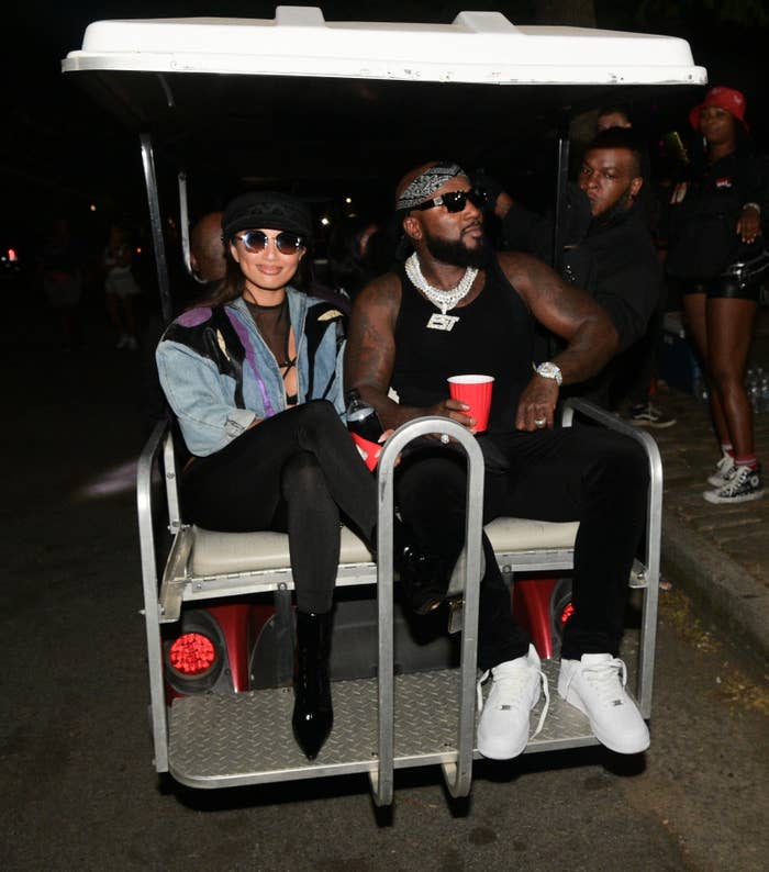 The former couple riding in the back of a golf cart