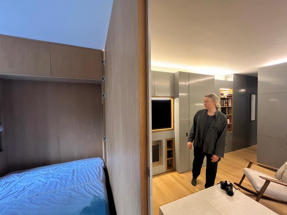 A view from the doorway between the new bedroom and the partitioned living room, with Robert Garneau standing near the couch. 