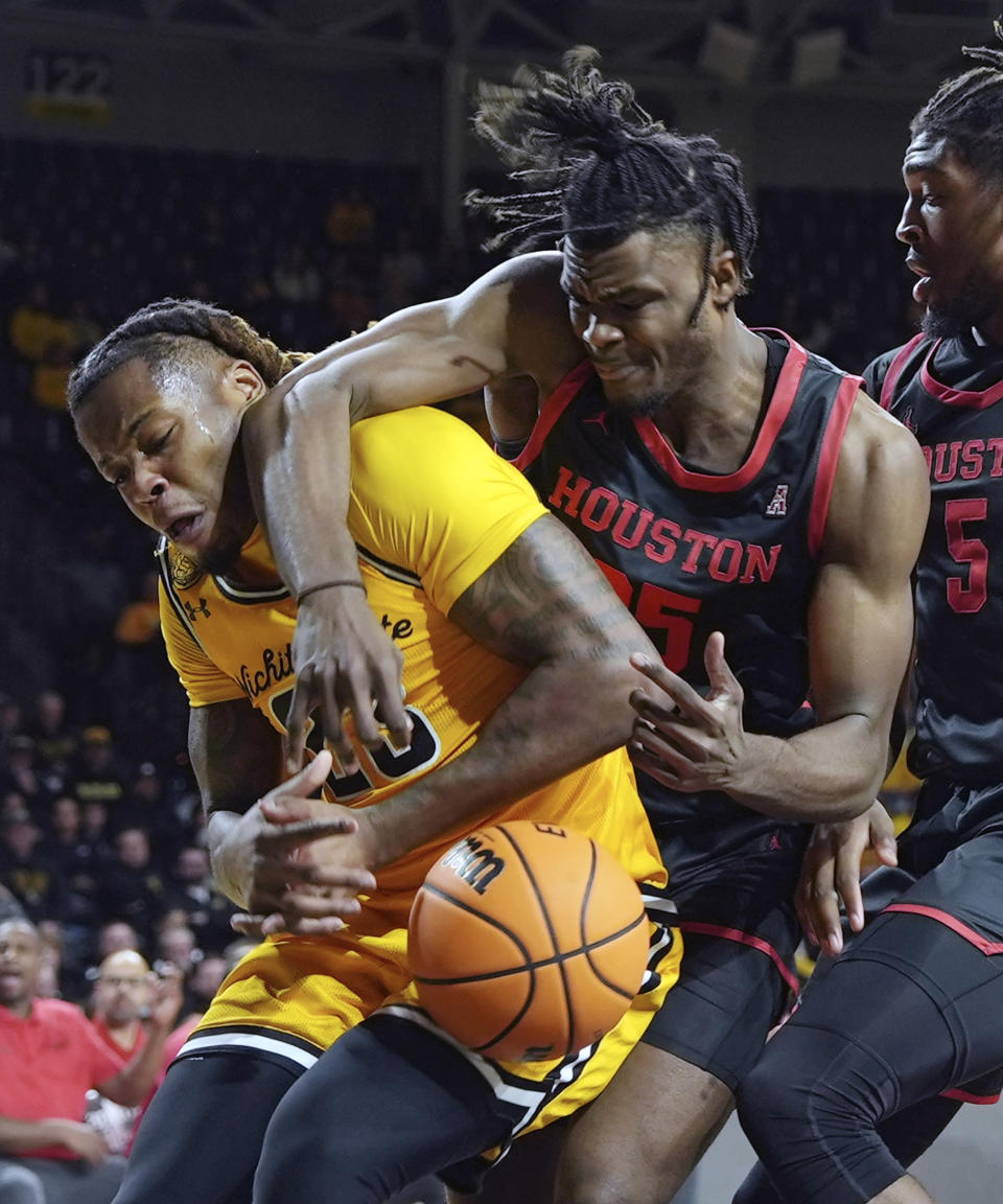 Wichita State's Gus Okafor, left, and Houston's Jarace Walker scramble for the ball during the first half of an NCAA college basketball game in Wichita, Kan., Thursday, Feb. 2, 2023. (Jaime Green/The Wichita Eagle via AP)