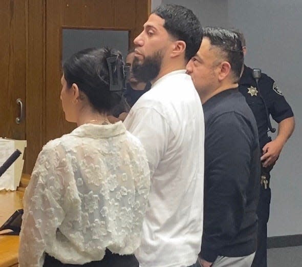 Luis Lopez, center and facing a charge of first-degree murder in the death of a Central Falls barber, appeared in District Court, Providence.