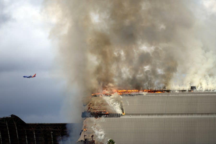 A historic blimp hangar burns in Tustin, Calif., Tuesday, Nov. 7, 2023. A fire destroyed a massive World War II-era wooden hangar that was built to house military blimps based in Southern California. (AP Photo/Jae C. Hong)