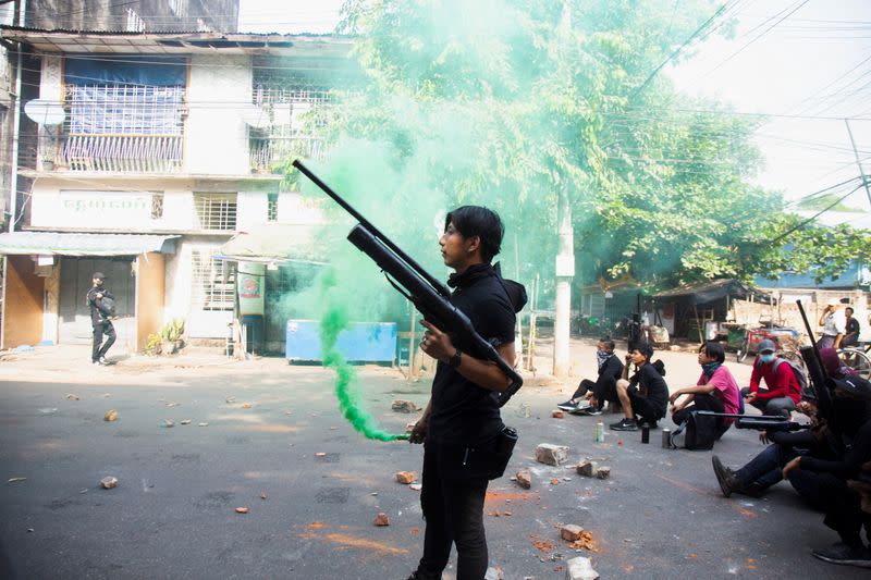 A protester holds a homemade pipe air gun during a protest against the military coup in Yangon