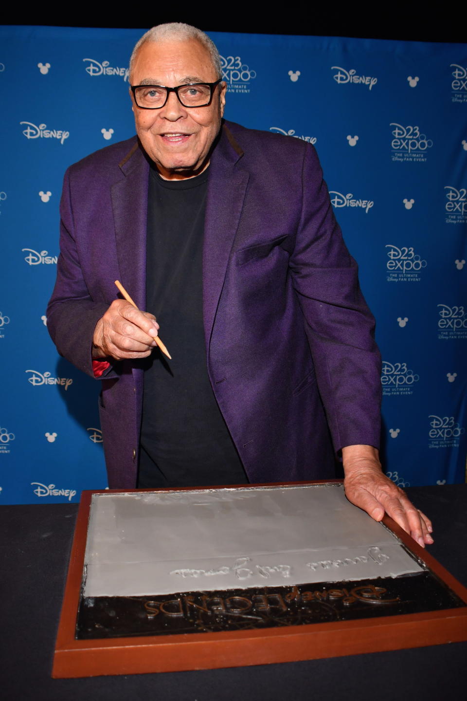 James Earl Jones is shown casting his hand in cement for Disney during a special event