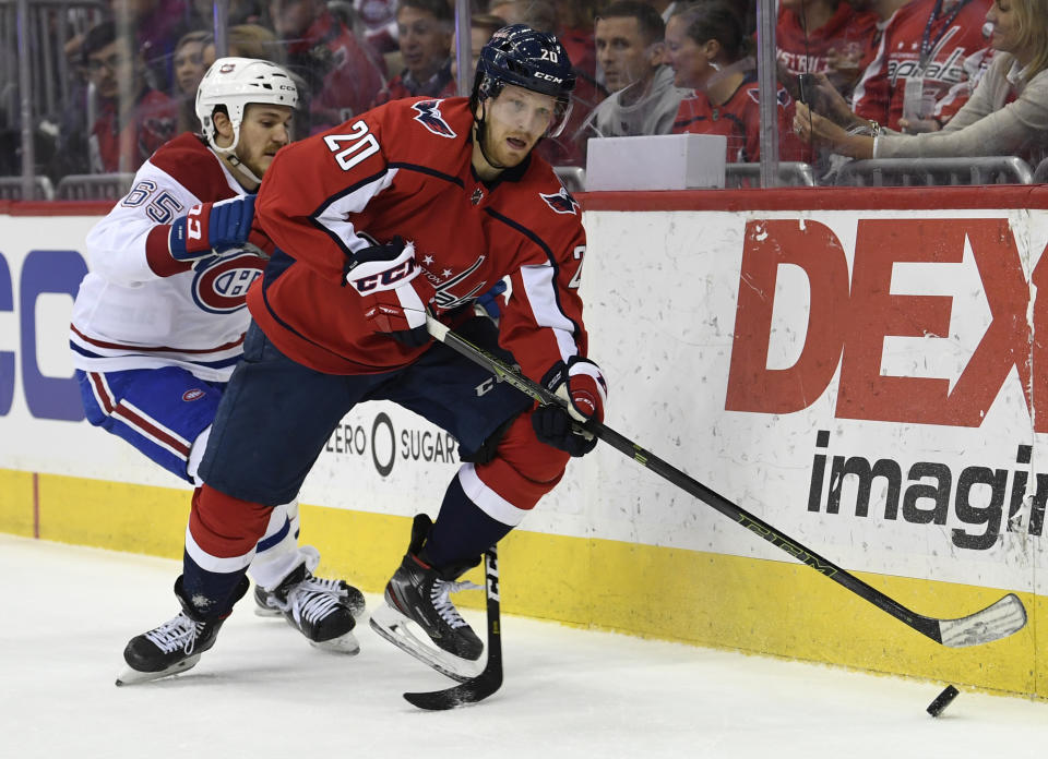 Washington Capitals Lars Eller (20), or Denmark, carries the puck under pressure from Montreal Canadiens Andrew Shaw (65) during the second period of their NHL hockey game in Washington, Thursday, April 4, 2019. (AP Photo/Susan Walsh)