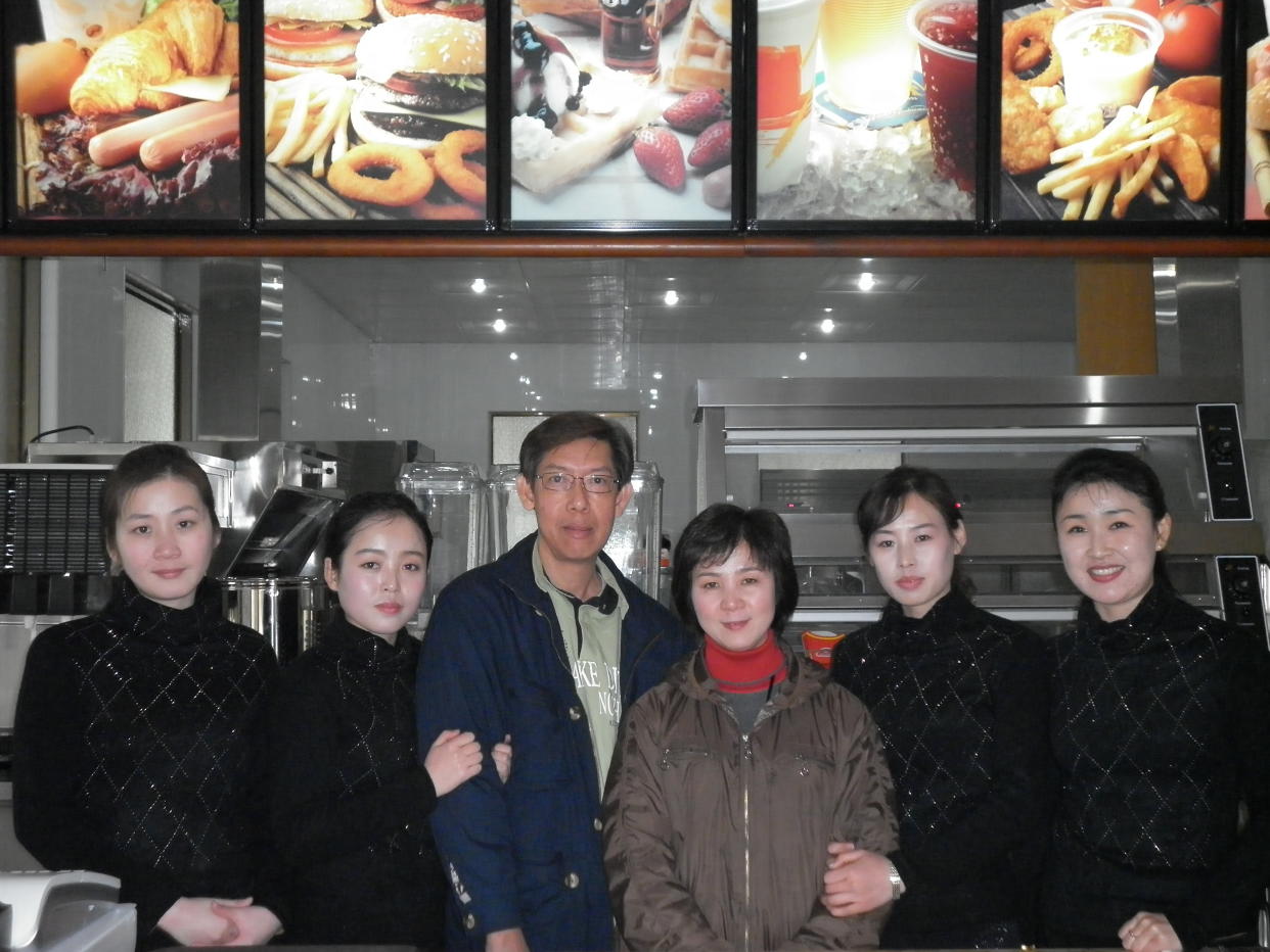 Patrick Soh (in blue jacket) posing with staff members at a Samtaesong outlet in Pyongyang. (PHOTO: Courtesy of Patrick Soh)