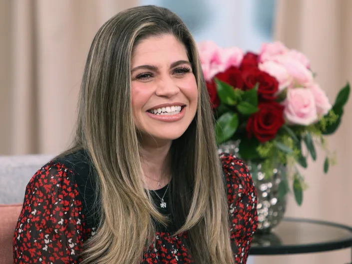 Danielle Fishel laughing in red dress.