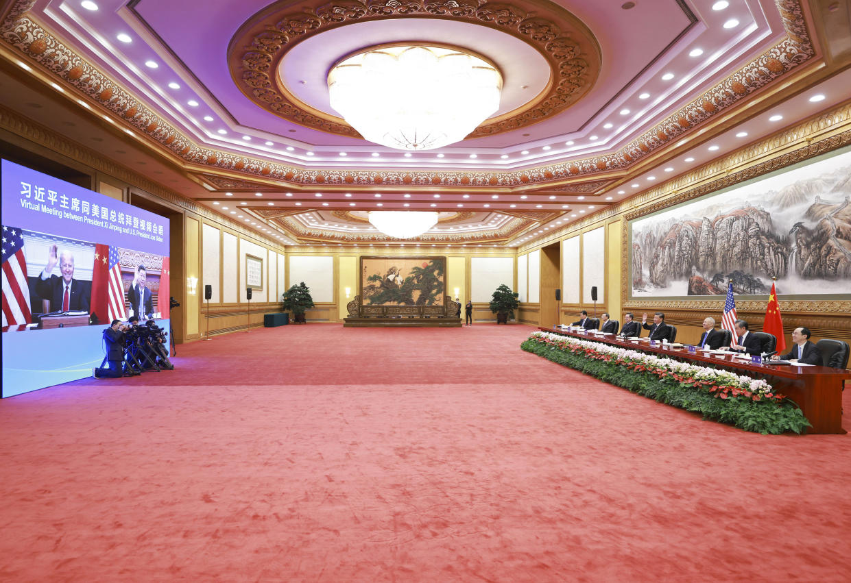 In this photo released by Xinhua News Agency Chinese President Xi Jinping, fourth from right waves as he greets U.S. President Joe Biden via video link from Beijing, China on Tuesday, Nov. 16, 2021. Biden opened his virtual meeting with Xi by saying the goal of the two world leaders should be to ensure that competition between the two superpowers "does not veer into conflict." (Ding Lin/Xinhua via AP)