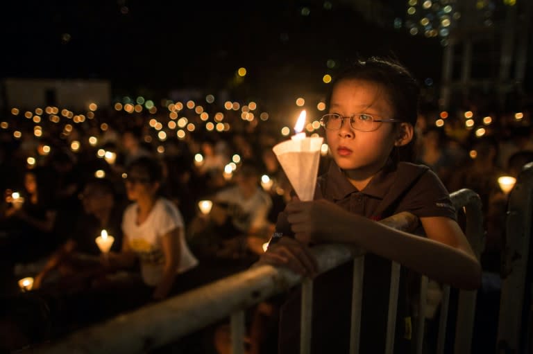 A young girl holds her candle at a vigil in Hong Kong on June 4, 2016, during the commemoration of the bloody Tiananmen Square crackdown