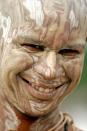 A Brahmin boy with his face smeared with ash smiles as he performs rituals on the banks of the River Ganges in Allahabad, India, Saturday, Aug. 16, 2008. Brahmins, or Hindu upper castes, believe that performing rituals on this day will wash away their sins. (AP Photo/Rajesh Kumar Singh)