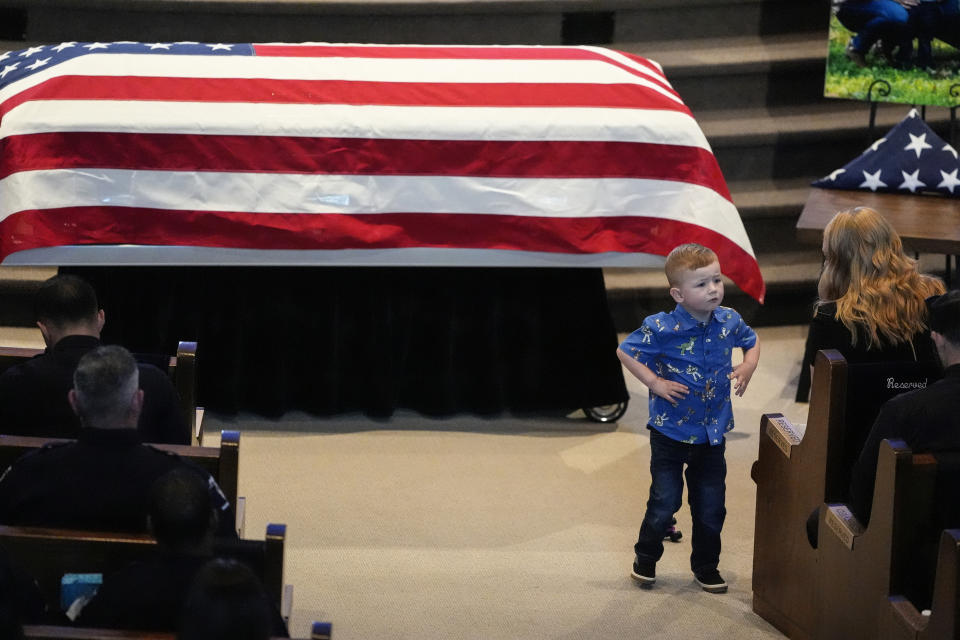 Andrew Brian Eyer, the son of slain officer Joshua Eyer, speak to his mother Ashley Eyer during a memorial service for Officer Joshua Eyer, Friday, May 3, 2024, in Charlotte, N.C. Police in North Carolina say a shootout that killed and Eyer and wounded and killed other officers began as officers approached a home to serve a felony warrant on Monday. (AP Photo/Chris Carlson)