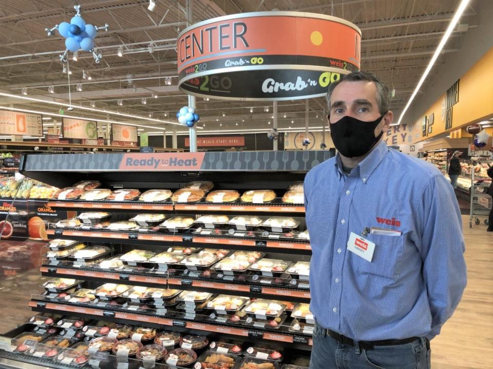 Harry Nelson, manager of the new Weis supermarket in Warminster, stands next to a display of prepared foods for shoppers to "Grab 'n Go."