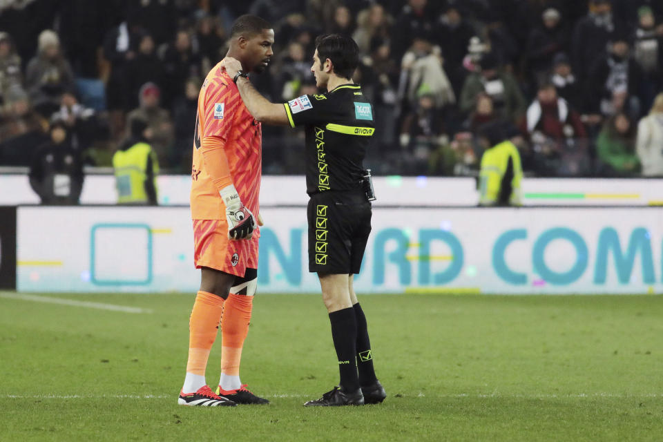 Referee Fabio Maresca, right, speaks to AC Milan's Mike Maignan during the Italian Serie A soccer match between Udinese and AC Milan that was suspended, at the Friuli stadium in Udine, Italy, Saturday, Jan. 20, 2024. Racist abuse aimed at AC Milan goalkeeper Mike Maignan prompted a top-tier Italian league game at Udinese to be suspended briefly during the first half. Maignan left the field after the insults which followed a goal for Milan. (Andrea Bressanutti/LaPresse via AP)