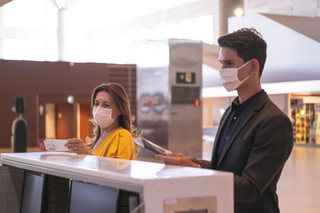 Photo of  businessman and woman at an airport making check in.