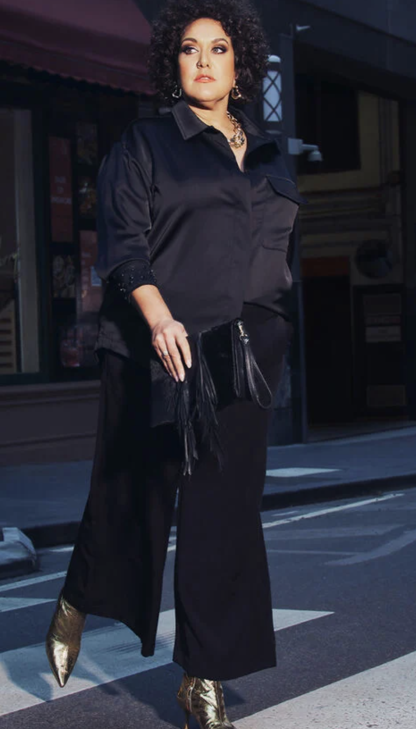 Casey Donovan wearing black shirt, Pin Tuck Trousers and metallic boots