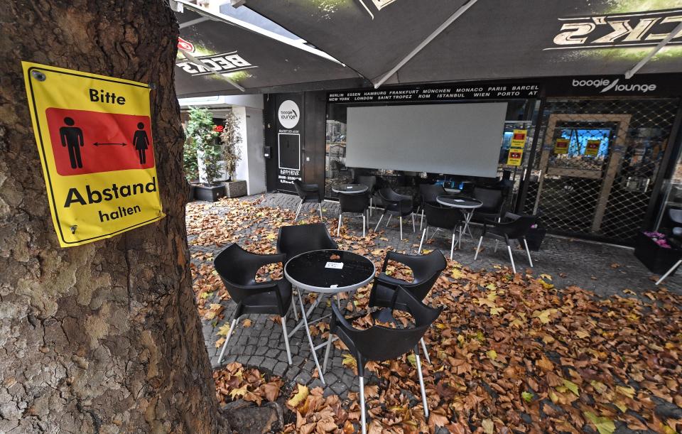 A sign reads 'Please keep distance' in front of a closed bar in the city center of Essen, Germany, Monday, Nov. 2, 2020. A one month long partial lockdown due to the coronavirus pandemic becomes effective in Germany on Monday. (AP Photo/Martin Meissner)