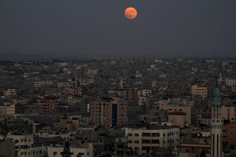 The supermoon rises in the sky over the houses of Gaza City, Wednesday, Aug. 30, 2023. The cosmic curtain rose Wednesday night with the second full moon of the month, the reason it is considered blue. It’s dubbed a supermoon because it’s closer to Earth than usual, appearing especially big and bright. (AP Photo/Adel Hana)