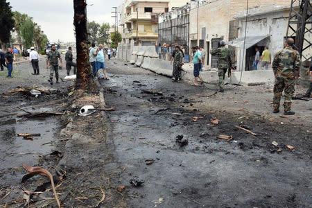 Men inspect damage after an explosion in the al-Zahraa neighbourhood of Homs city in this handout picture provided by SANA on May 23, 2017, Syria. SANA/Handout via REUTERS