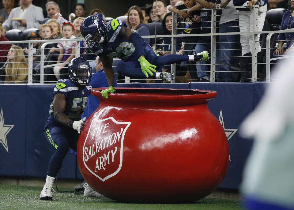 Dec 24, 2017; Arlington, TX, USA; Seattle Seahawks cornerback Justin Coleman (28) jumps out of a Salvation Army kettle with defensive end Frank Clark (55) after returning an interception for a touchdown against the Dallas Cowboys in the third quarter at AT&T Stadium. Mandatory Credit: Tim Heitman-USA TODAY Sports