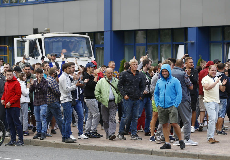 People gather during a rally against the results of the country's presidential election outside the Belarusian Automobile Plant (BelAZ) in Zhodino, about 50 km (31 miles) north-east of Minsk, Belarus, Thursday, Aug. 13, 2020. Hundreds of people were back on the streets of Belarus' capital on Thursday morning, forming long "lines of solidarity" in protest against an election they say was rigged to extend the rule of the country's authoritarian leader and against a crackdown on rallies that followed the vote. (AP Photo/Sergei Grits)