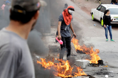 A demonstrator lights up a barricade during a protest against the re-election of Honduras' President Juan Orlando Hernandez in Tegucigalpa, Honduras January 20, 2018. REUTERS/Jorge Cabrera