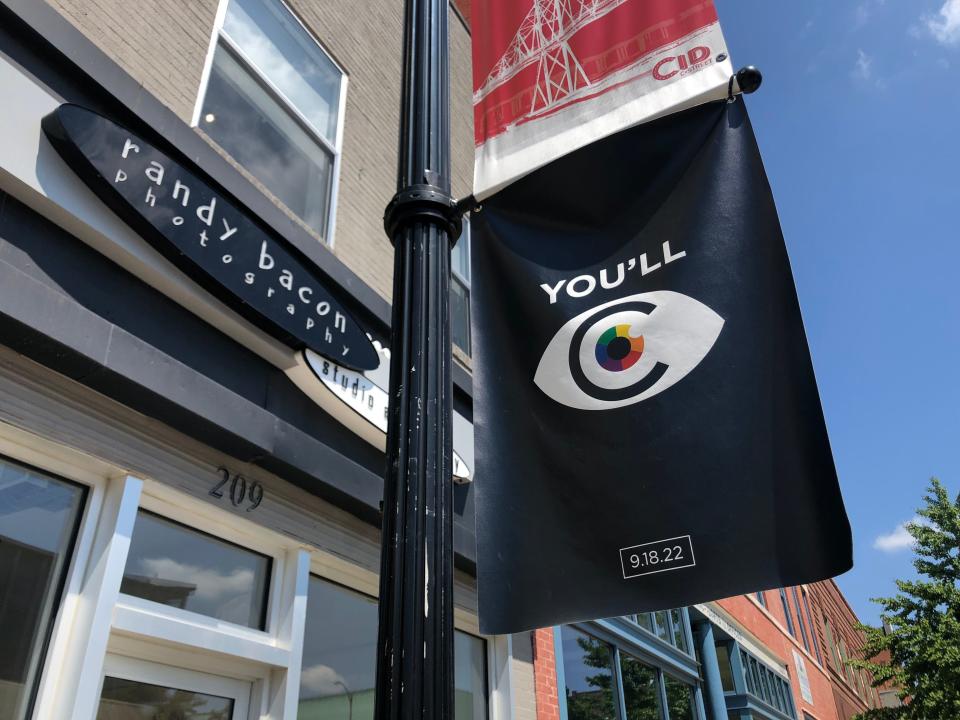 A black banner featuring an abstract eyeball and the date Sept. 17, 2022 hangs outside of Randy Bacon Photography Studio and Gallery on Commercial Street on Thursday, Aug. 25. The banner was a part of the "teaser" campaign for C-Art, a new, ongoing art event to take place along Commercial Street. The inaugural event is Sunday, Sept. 18 from 1-4 p.m. 20 local artists, 14 venues and two musical acts are participating. The family-friendly event is free.