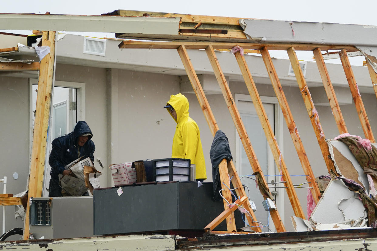 People salvage items from the second level of a building after a tornado hit Saturday, May 13, 2023, in the unincorporated community of Laguna Heights, Texas near South Padre Island. Authorities say one person was killed when a tornado struck the southernmost tip of Texas on the Gulf coast. (AP Photo/Julio Cortez)