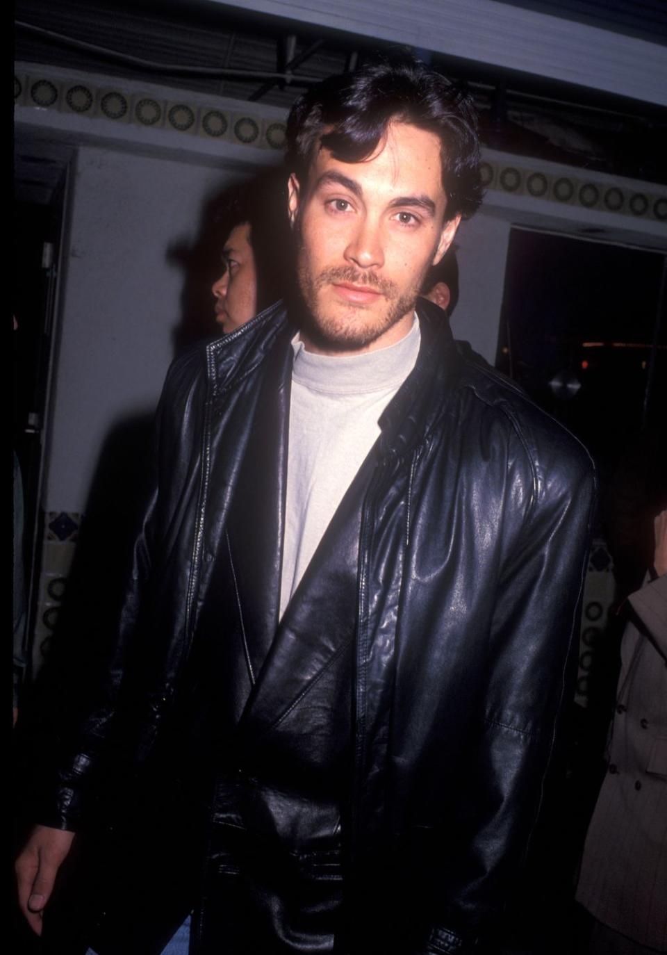 brandon lee wearing a black leather jacket and white shirt