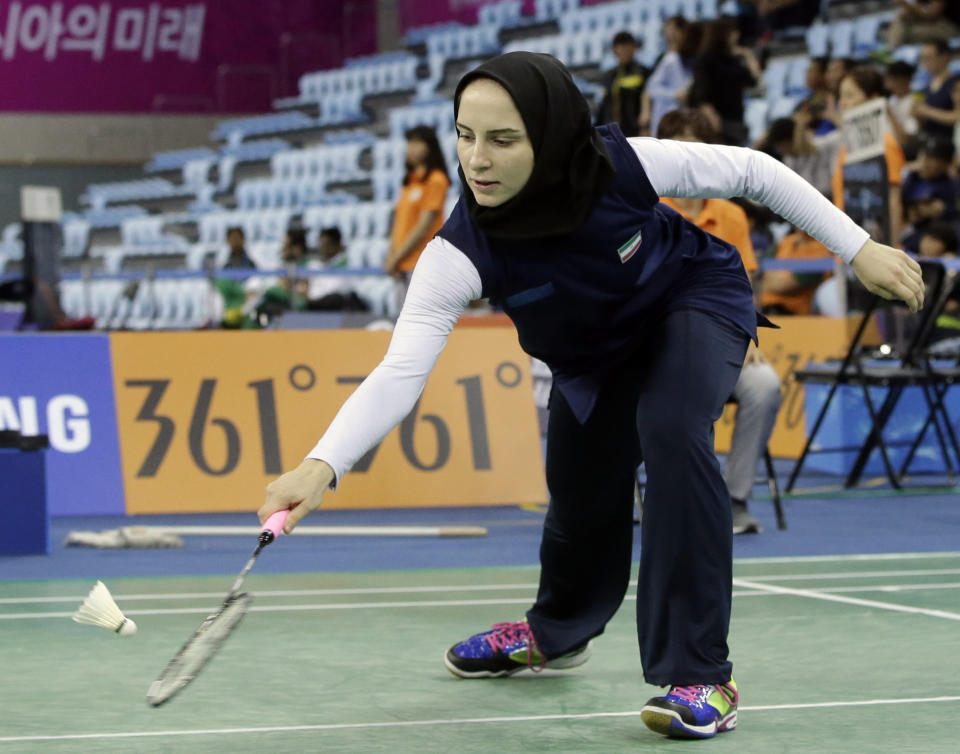 FILE - In this Wednesday, Sept. 24, 2014 file photo, Soraya Aghaeihajiagha of Iran returns the shuttlecock against Khulangoo Bataar of Mongolia during their wonen&#39;s singles badminton match at the 17th Asian Games in Incheon, South Korea. The Qatar women&#39;s basketball team forfeited its Asian Games match against Mongolia after players were refused permission to wear a hijab. Incheon Asian Games Organizing Committee spokeswoman Anna Jihyun You told The Associated Press on Wednesday, Sept. 24, that the players &quot;had refused to take off the hijab&quot; and the match was awarded to the opposition. (AP Photo/Dita Alangkara, File)