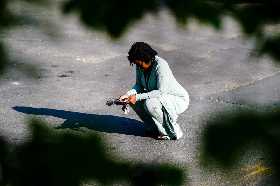 FILE - A woman pauses outside the scene of a shooting at a supermarket, in Buffalo, N.Y., Sunday, May 15, 2022. A white man is accused of shooting 13 people Saturday at the Tops Friendly Market in a predominantly Black neighborhood of Buffalo. Long before an 18-year-old avowed white supremacist inflicted terror at a Buffalo supermarket, the city's Black neighborhoods, like many others around the nation, had been dealing with wounds that are generations old. (AP Photo/Matt Rourke, File)