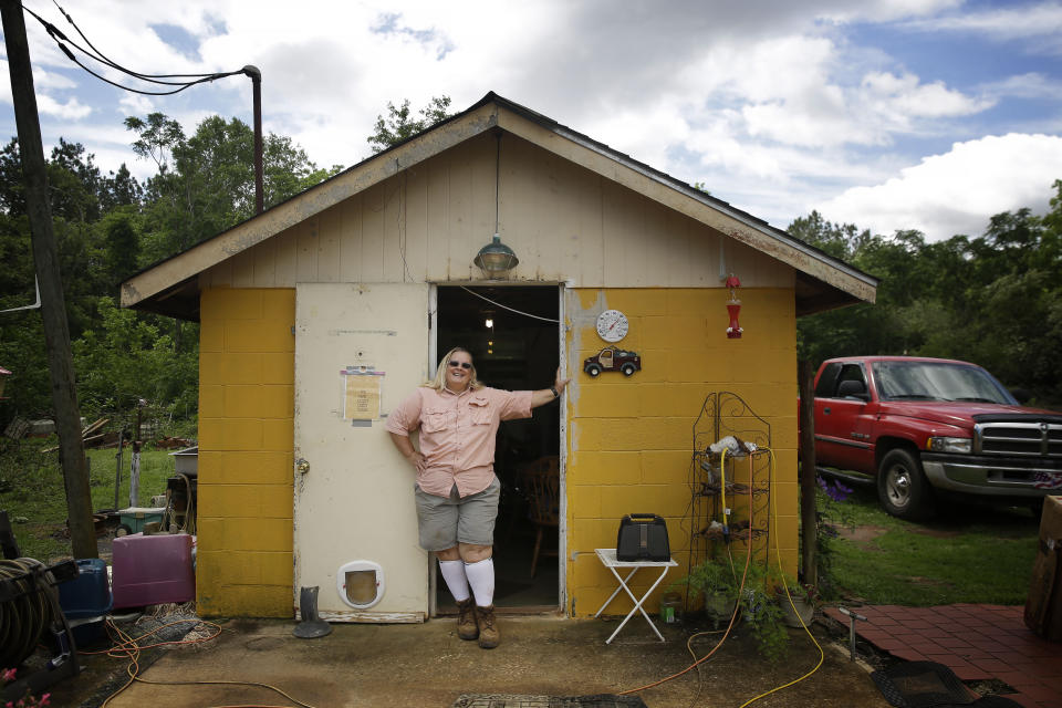 In this Monday, April 20, 2020, photo, Georgia farmer Jerilyn Morgan leans against her shop on her vegetable farm in Dawson, Ga. Gov. Brian Kemp announced plans Monday to restart the state's economy before the end of the week, saying many businesses that closed to mitigate the spread of the coronavirus could reopen as early as Friday. "I'm not in a rush to open it back up, even though it's going to cost me money and my vegetables will go bad, lives come before my pocketbook," said Morgan. (AP Photo/Brynn Anderson)