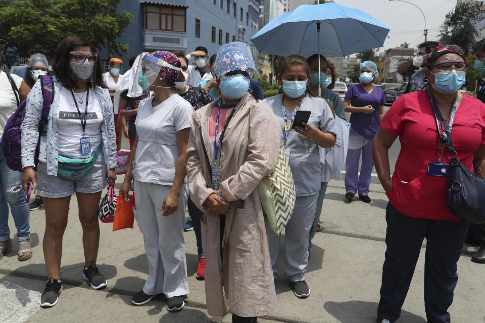 Medical workers who say they work directly with COVID-19 patients stand outside the public Rebagliati Hospital where they say work where other health workers get shots of China's Sinopharm vaccine during a priority vaccination campaign inside the facility in Lima, Peru, Wednesday, Feb. 10, 2021. The group complained that they are not on the list of medical workers to be vaccinated and that some people getting shots do not work directly with COVID-19 patients. (AP Photo/Martin Mejia)