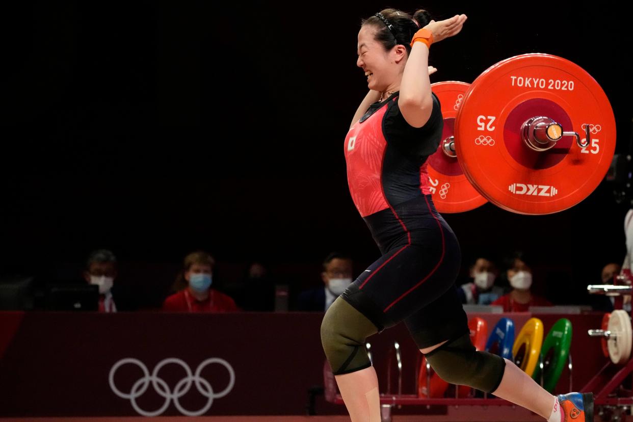 Mikiko Andoh of Japan celebrates after dropping the barrel during a lift in the women's 59kg weightlifting event at the 2020 Summer Olympics, Tuesday, July 27, 2021, in Tokyo, Japan.