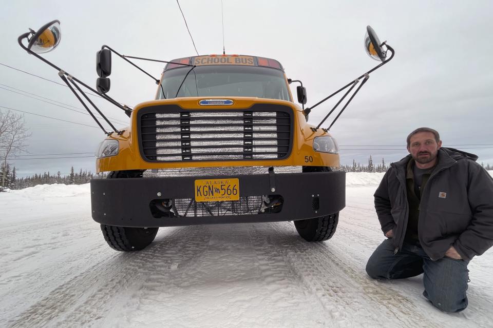 Stretch Blackard, owner of Tok Transportation, poses with an electric school bus on Feb. 2, 2023, in Tok, Alaska. “It is a problem to have batteries in cold weather, and we have a pretty cold climate, one of the coldest in North America,” said Blackard, owner of Tok Transportation, which contracts with the local schools to carry students. (AP Photo/Mark Thiessen)