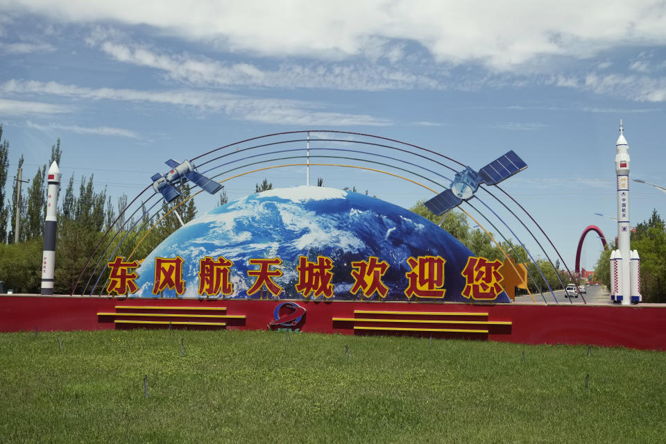 A scene depicting Long March rockets, Shenzhou module, Space station and satellite is seen at a welcoming sign that reads, "Dong Feng Space City welcomes you" near the Jiuquan Satellite Launch Center in Jiuquan in northwestern China, Wednesday, June 16, 2021. China has launched the first three-man crew to its new space station in its the ambitious programs first crewed mission in five years. (AP Photo/Ng Han Guan)