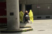 A patient is brought to Jackson Health Center by paramedics wearing protective clothing in Miami