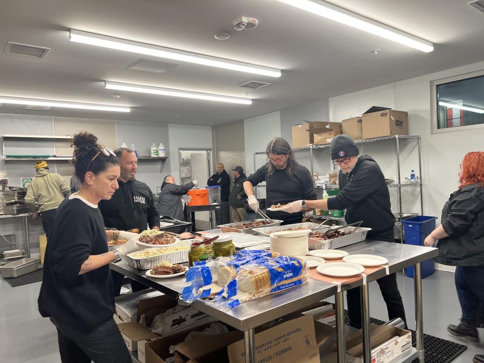 Foo Fighters rocker Dave Grohl prepares and serves barbecue at a Los Angeles shelter. (Photo: Hope the Mission)