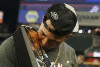 Atlanta Braves left fielder Eddie Rosario kisses the Most Valuable Player trophy after winning Game 6 of baseball's National League Championship Series against the Los Angeles Dodgers Sunday, Oct. 24, 2021, in Atlanta. The Braves defeated the Dodgers 4-2 to win the series. (AP Photo/Brynn Anderson)