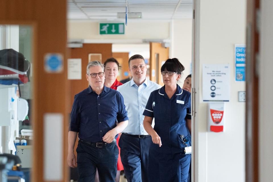Sir Keir Starmer and Wes Streeting walk through a hospital corridor accompanied by a nurse (PA Wire)