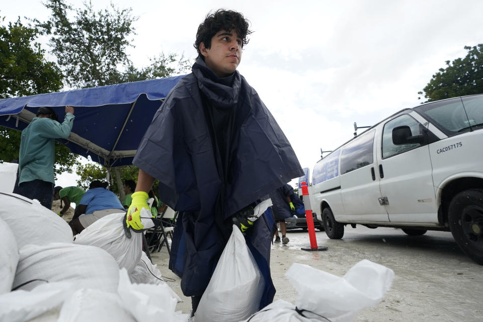 City worker Enrique Pulley prepares to load sandbags at a drive-thru sandbag distribution event for residents ahead of the arrival of rains associated with tropical depression Fred, Friday, Aug. 13, 2021, at Grapeland Park in Miami. Forecasters say tropical depression Fred is slowly strengthening and could regain tropical storm status Friday. (AP Photo/Wilfredo Lee)