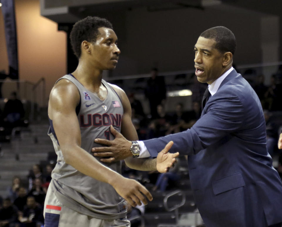 FILE - Connecticut head coach Kevin Ollie, right, talks with Christian Vital during the second half of an NCAA college basketball game against Cincinnati in Highkland Heights, Ky., in this Thursday Feb. 22, 2018, file photo. Former Connecticut head coach Kevin Ollie has been brought on board in a leadership role for a new basketball league designed to offer elite high school players another pathway to the pros. Ollie will serve as coach and director of player development for Overtime Elite, which markets itself to 16-to-18 year old players with guarantees of academic education and a six-figure salary. (AP Photo/Tony Tribble, File)