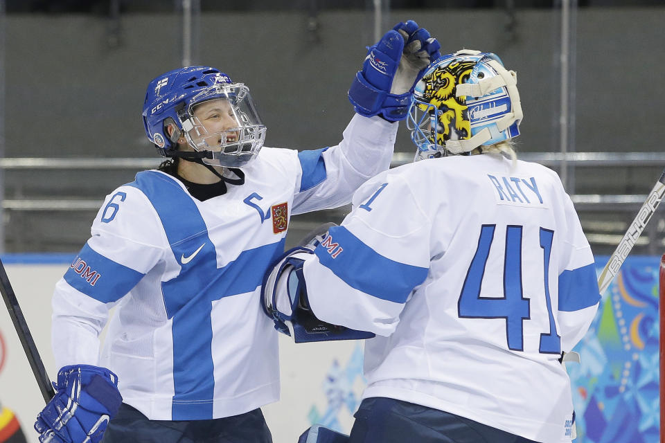 Jenni Hiirikoski of Finland celebrates their 2-1 win over Germany with goalkeeper Noora Raty after the 2014 Winter Olympics women's ice hockey game at Shayba Arena, Sunday, Feb. 16, 2014, in Sochi, Russia. (AP Photo/Matt Slocum)