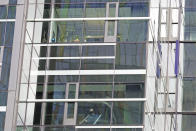 A worker cleans a window in an Amazon.com office building, Thursday, April 30, 2020, in downtown Seattle. Amazon is expected to announce earnings for the first quarter of 2020 at the close of markets Thursday, a report that is expected to be closely watched due to the effects of the coronavirus outbreak on the company. (AP Photo/Ted S. Warren)