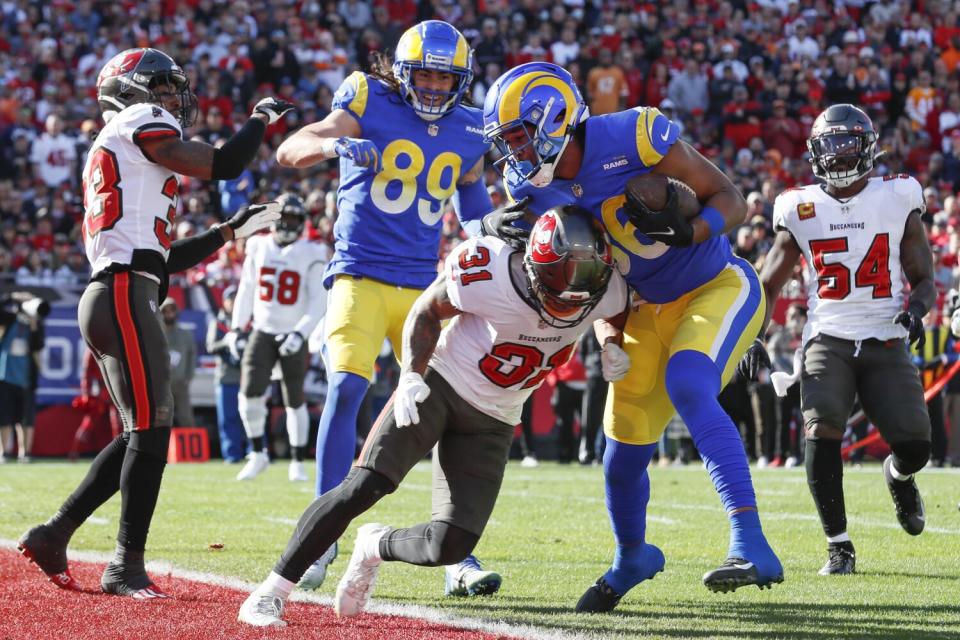 Rams tight end Kendall Blanton scores a touchdown as he is hit by Tampa Bay Buccaneers defensive back Antoine Winfield II.