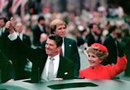 U.S. President Ronald Reagan gives a thumbs up sign to the crowd as his wife, first lady Nancy Reagan, waves from limousine during the inaugural parade in Washington, D.C., Jan. 20, 1981. Earlier, Reagan was sworn in as the 40th president of the United States. (AP Photo)