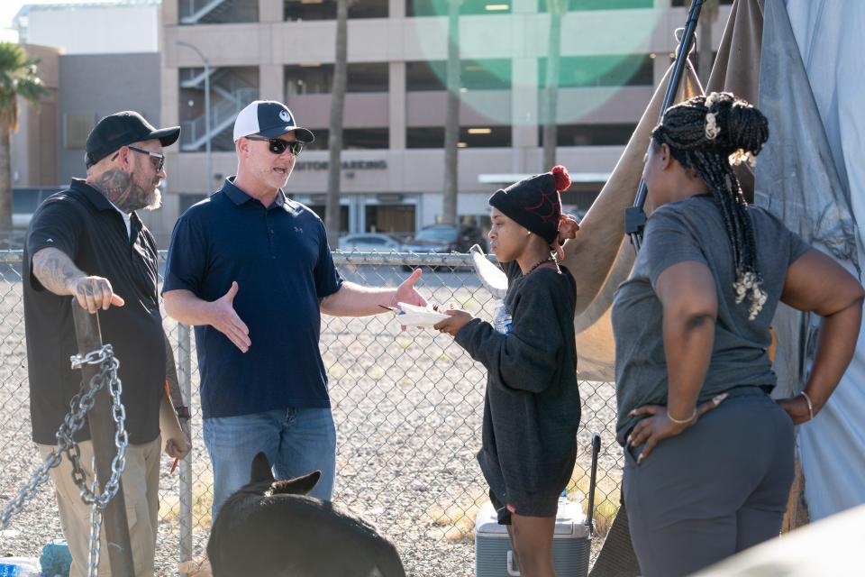 Scott Hall (second from left), City of Phoenix deputy director of the Office of Homeless Solutions, talks with a homeless person (second from right) on June 21, 2023, during cleanup of "The Zone" homeless encampment on Madison Street between Eighth and Ninth avenues in Phoenix.
